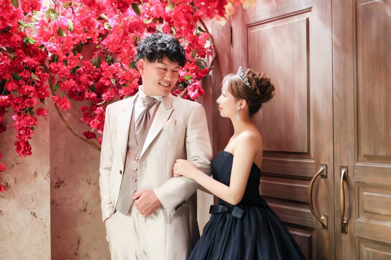 赤い花々に映える、お二人の視線