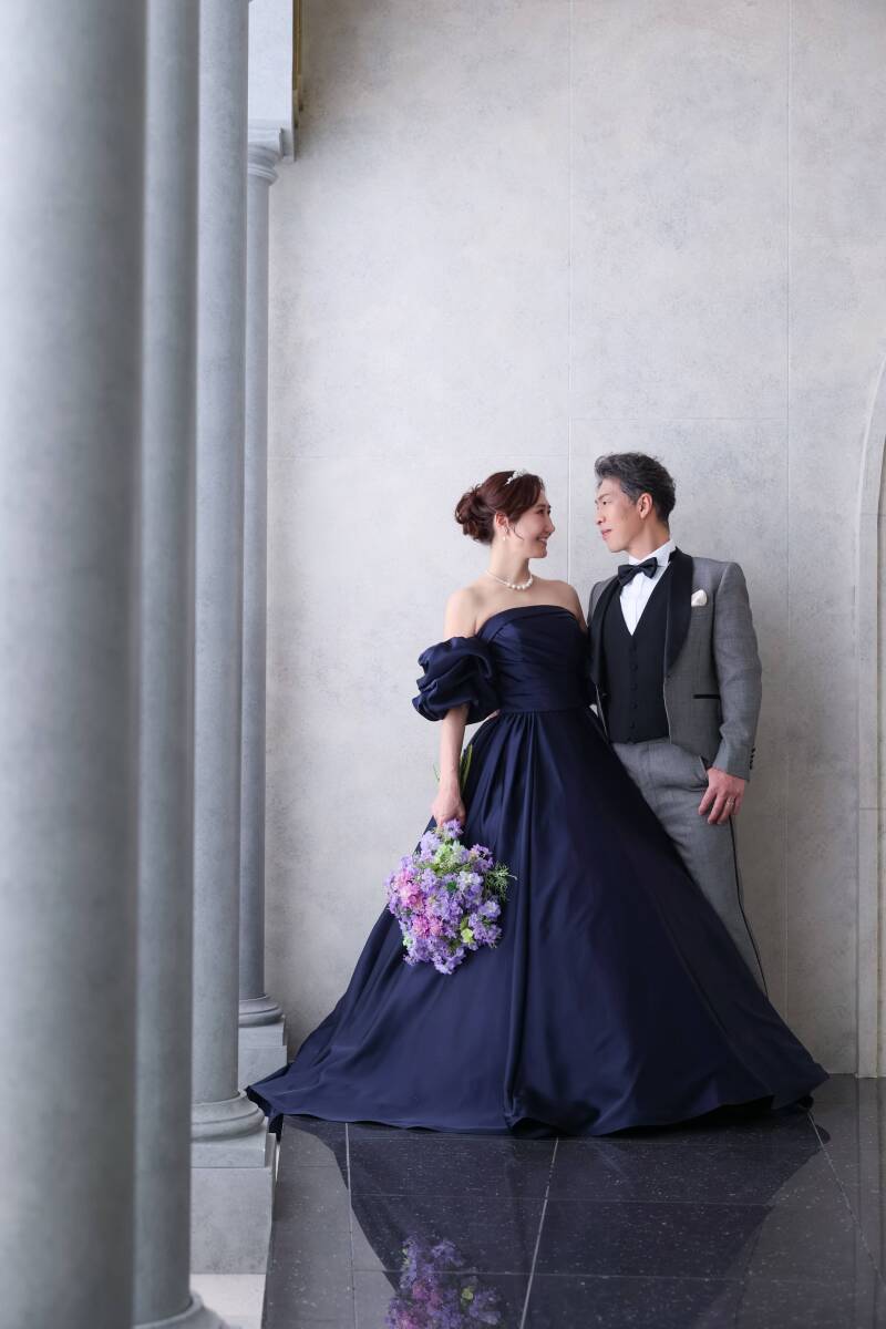 クラシカルな柱廊に佇む、洗練されたドレス姿