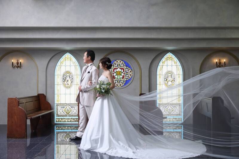 ステンドグラスを背に、ロングベールが描く曲線美