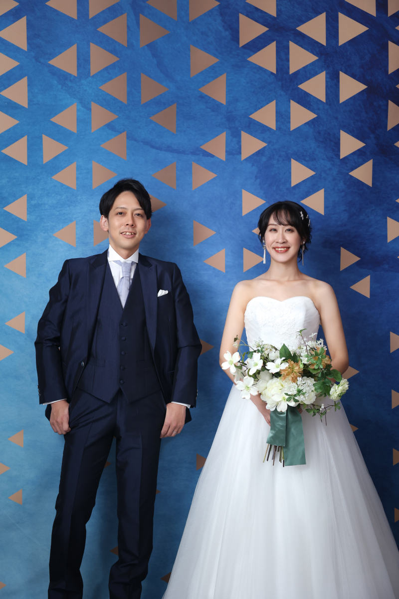 鮮やかなブルーをバックに爽やかな笑顔で