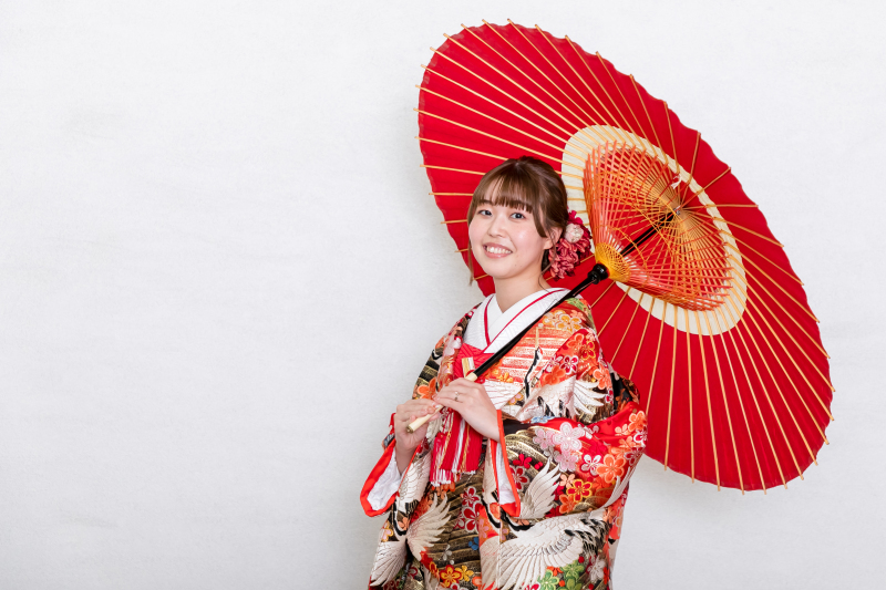 お着物の色と合わせた和傘を持って