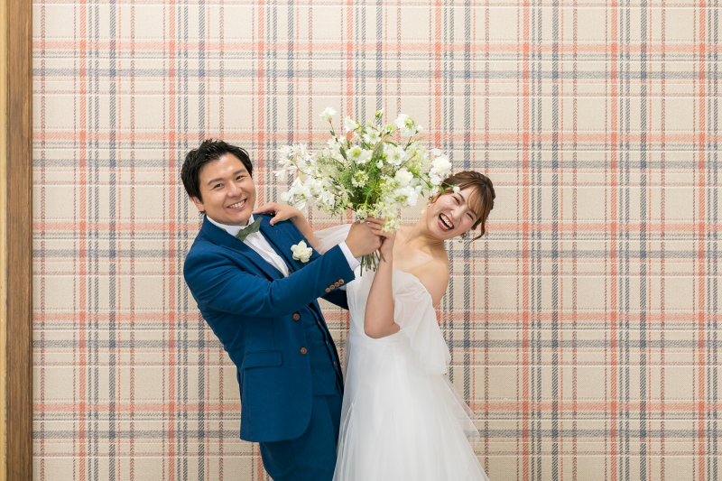 二人でブーケの影から素敵な笑顔