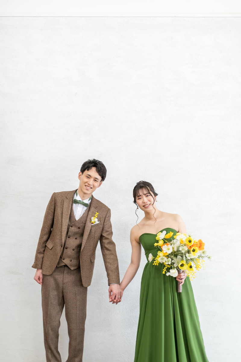 シンプルな背景で二人で手を繋いでハイチーズ