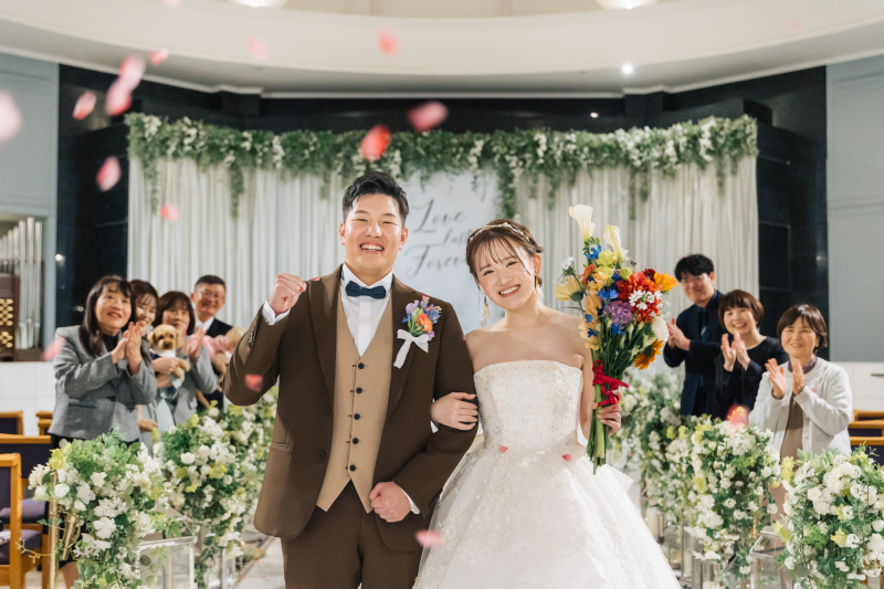 「笑顔が弾ける瞬間、その空気ごと写したい。」扉を開けて歩き出したその一歩。花びらが舞い、拍手が響き、おふたりの笑顔が自然とこぼれた瞬間を一枚の写真にぎゅっと閉じ込めました。