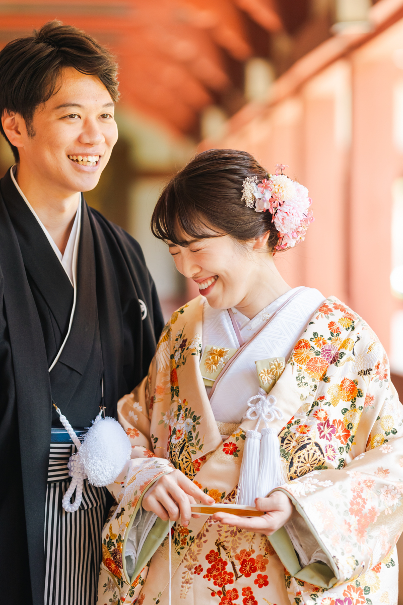 「伝統の中にも、おふたりらしい“やさしさ”を。」色とりどりのお着物に、やわらかな光が差し込み、くしゃっと笑った花嫁さんの表情がとても印象的。ふたりのあたたかな関係性も一枚に重ねたような写真です。