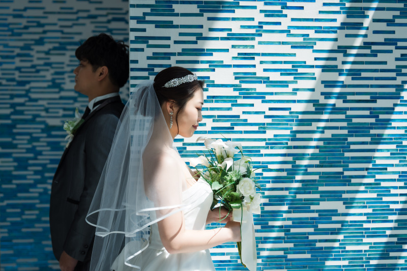 爽やかなブルーに映えるおふたりと日差し