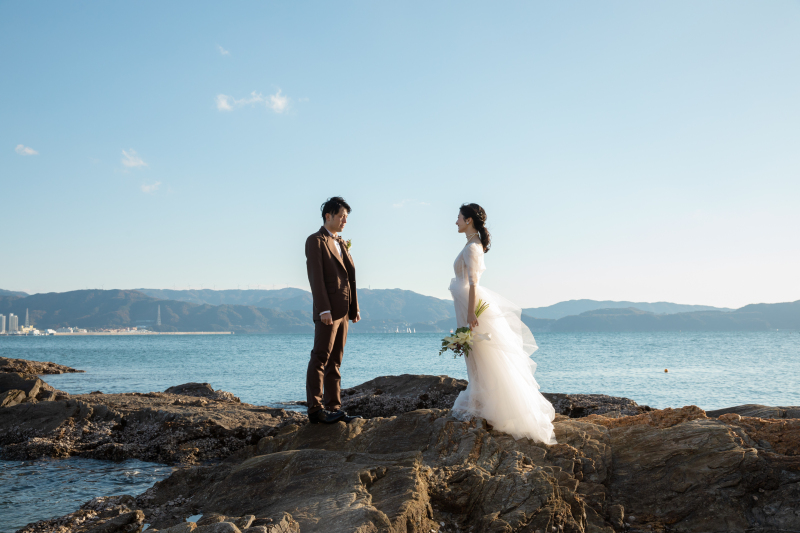 二人のシルエットを岩場越しで。