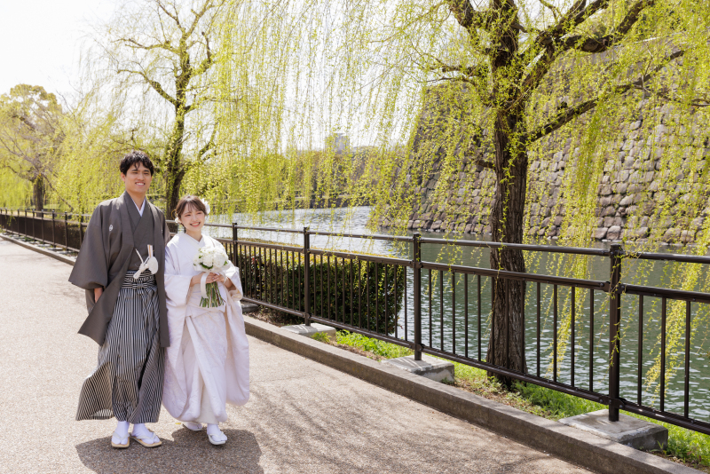 ロケーションの景色の中を並んで歩くおふたり