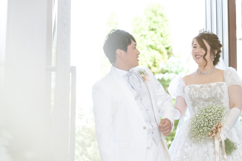 チャペル入口での1コマ。緑を背景に笑顔のお二人