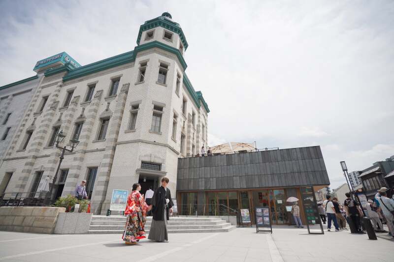 趣ある建物の前で