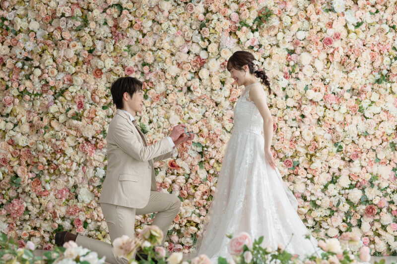 お花いっぱいの背景の前で