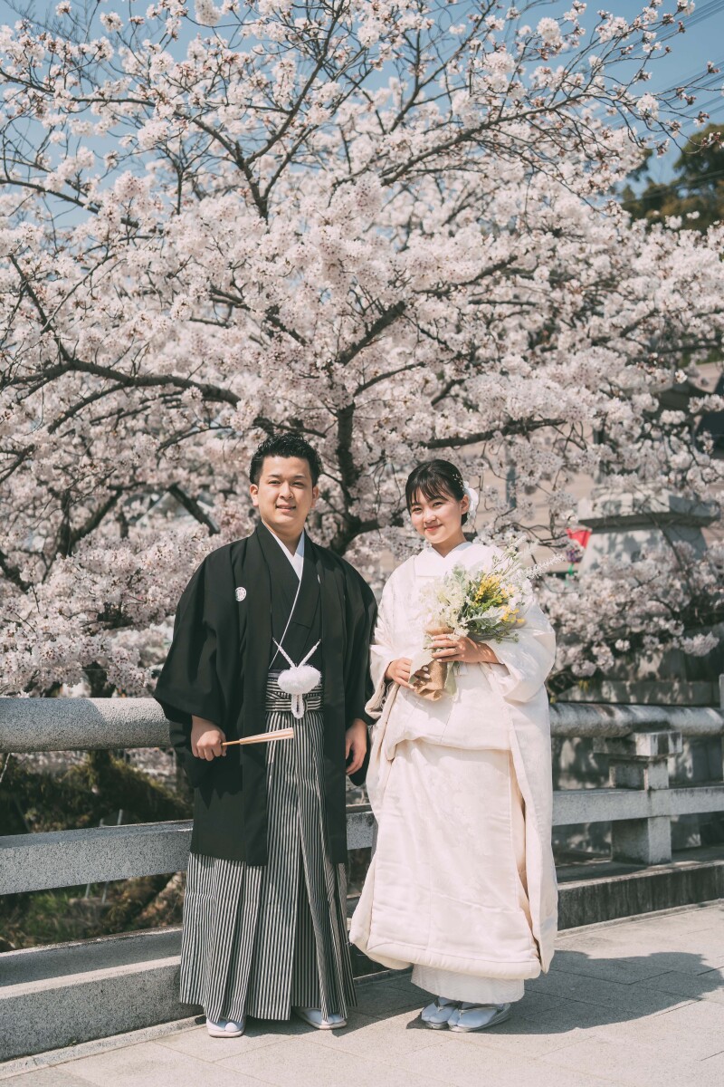 満開の桜の木の前で