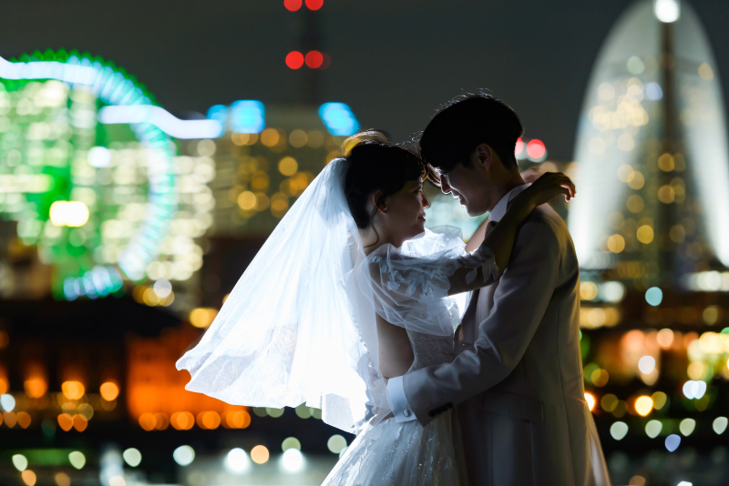 横浜のライトアップされた景色をバックに