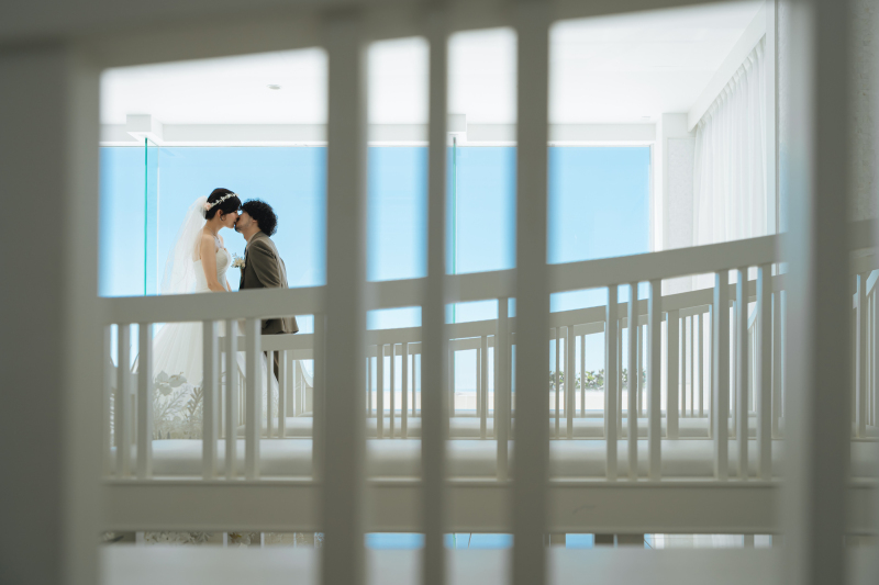 白亜のチャペルで誓いのキスを交わすお二人の姿