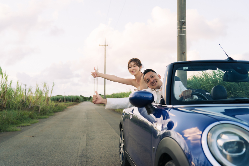 ミニクーパーのオープンカーでヒッチハイクポーズを