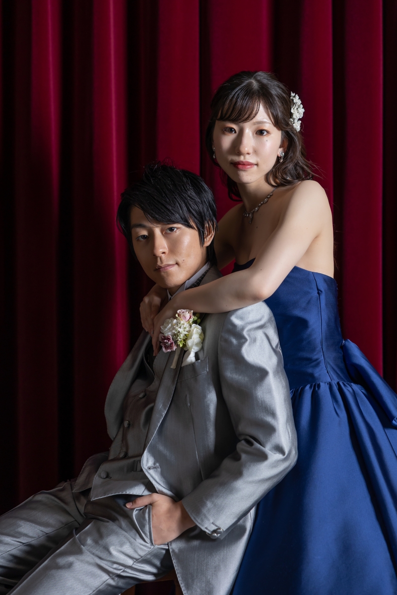 赤いカーテンの前で