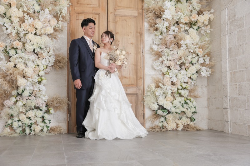 お花に囲まれた扉の前で