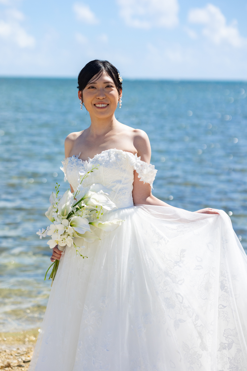海を背に見せる新婦のナチュラルな笑顔が魅力