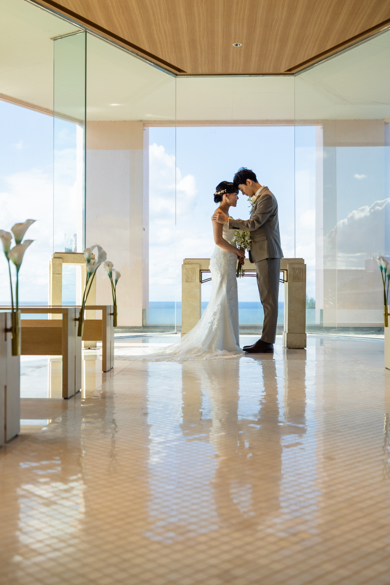 青い海を背景に、おでこを合わせるふたり