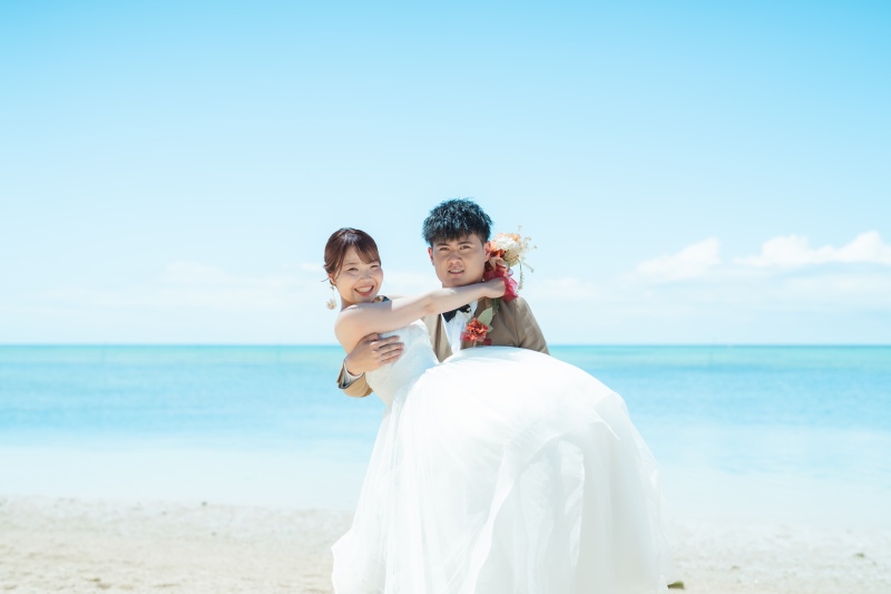 海をバックにお姫様抱っこのポーズで素敵です♡