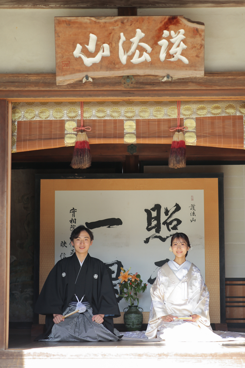 「照千一隅」の文字の前で