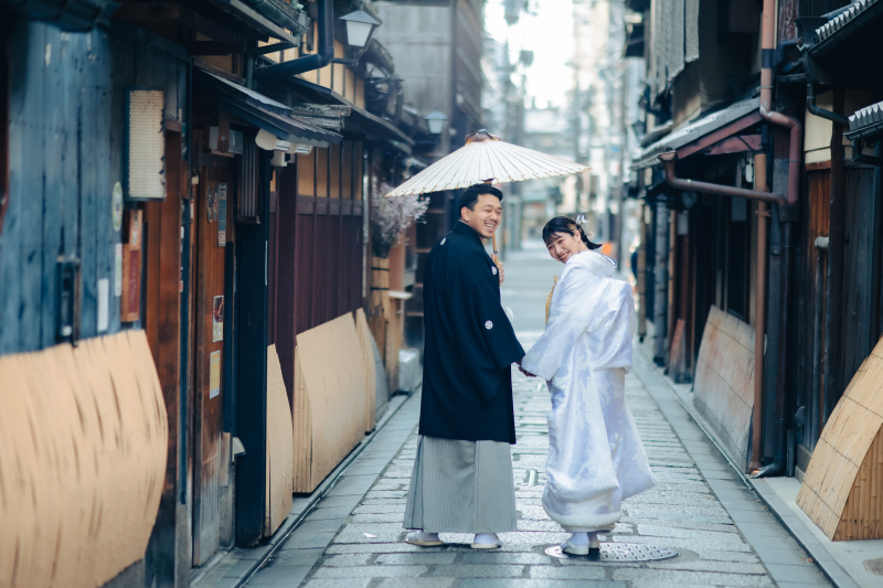 相合傘の下、手を繋いだ振り向きショット