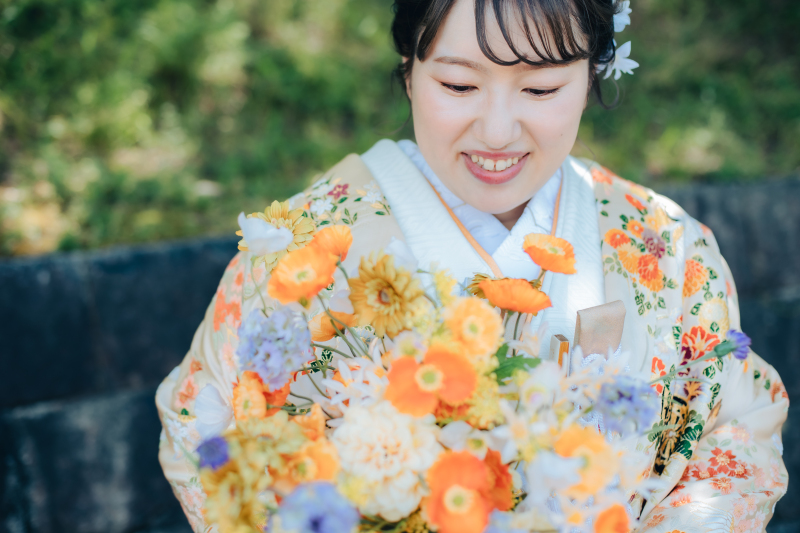 ソロショットでは衣装と色味の揃ったブーケと共に