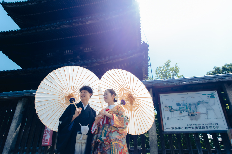 塔のふもと、傘を広げて光の中へ