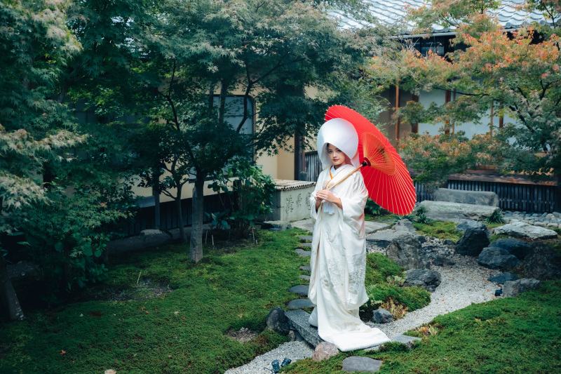 寺院内の庭園では綿帽子と番傘を携えて