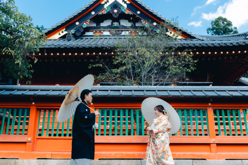 朱色のお堂の前で