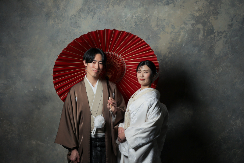 白無垢にアクセントの赤の番傘を使って