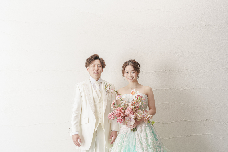 まずはカラードレスが引き立つ白壁で撮影