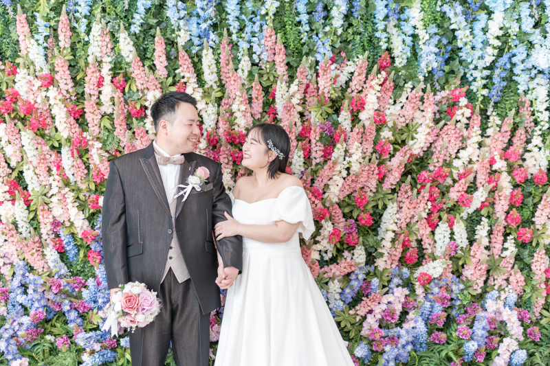 いっぱいのお花のバックに腕組み