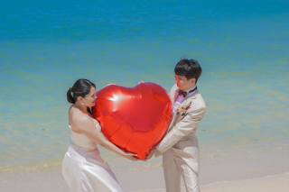 アラハビーチで赤いハートアイテムとともに笑顔あふれるフォトウェディング