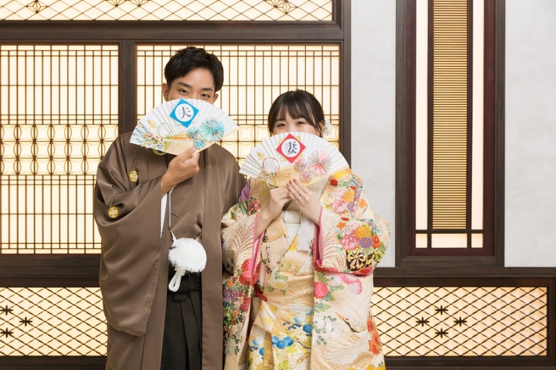 扇子で口元を隠して