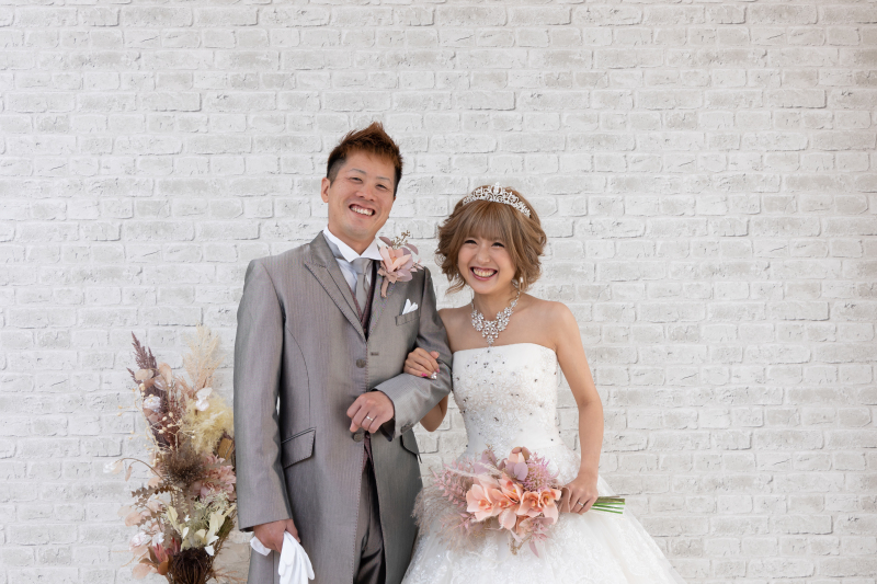 レンガの壁の前でお二人ショット