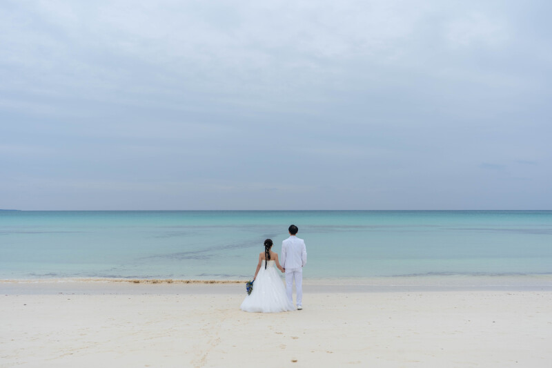 手を取り合い、海へと歩み出す