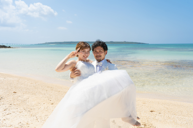 青いビーチでお姫様抱っこでピース!