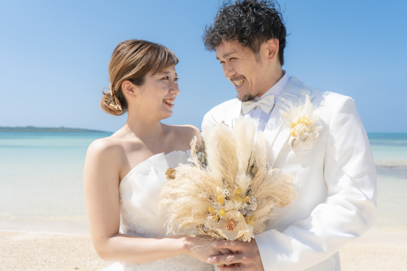 ブーケを握りあいながら笑顔あふれるふたり