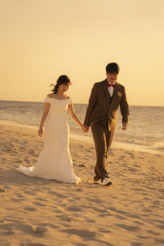 オレンジ色に染まる空と静かな海を背景に、手をつなぎながらゆっくりと歩くおふたりの姿。足元に映る影と、寄せては返す波の音が、優しく一日を締めくくります。言葉はなくても、ふたりの心が自然に通い合うような。