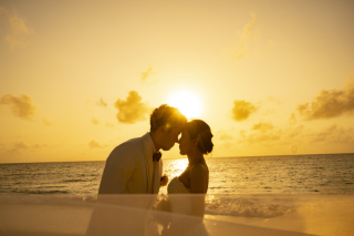 夕陽に染まる宮古島のサンセットとともに、風に揺れるベールが海辺をやさしくなぞる一枚。時間がゆっくりと流れる中で、おふたりのシルエットがやさしく浮かび上がり、まるで映画のような幻想的な光景が広がります。