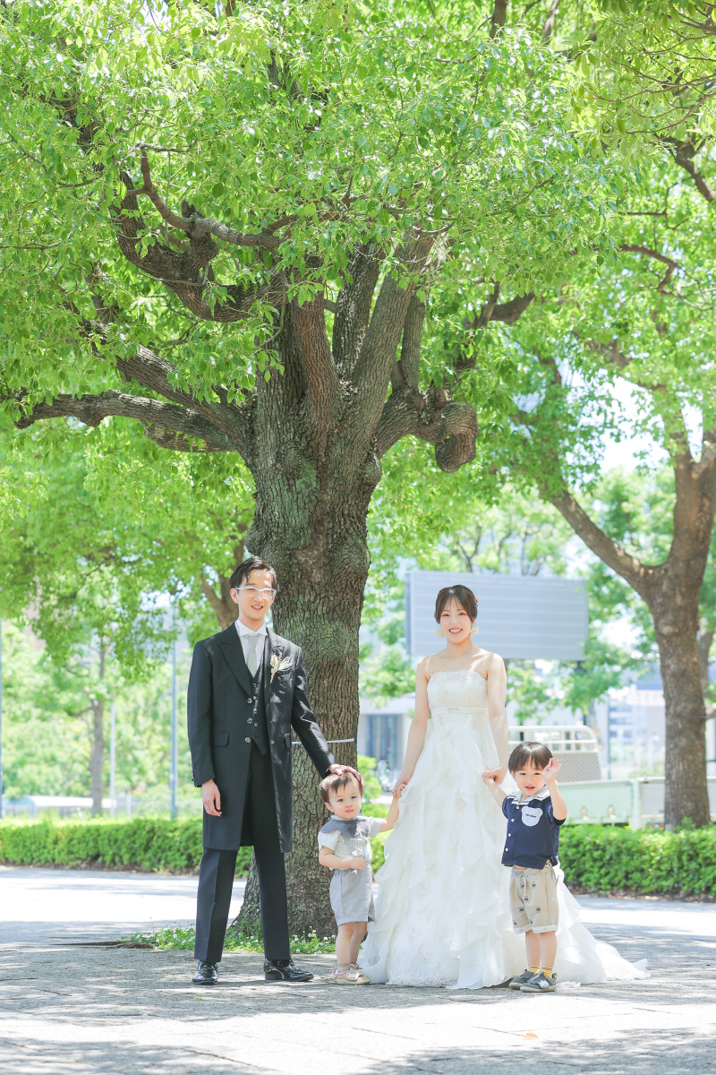 大きな木の下で集う、特別な日の家族写真