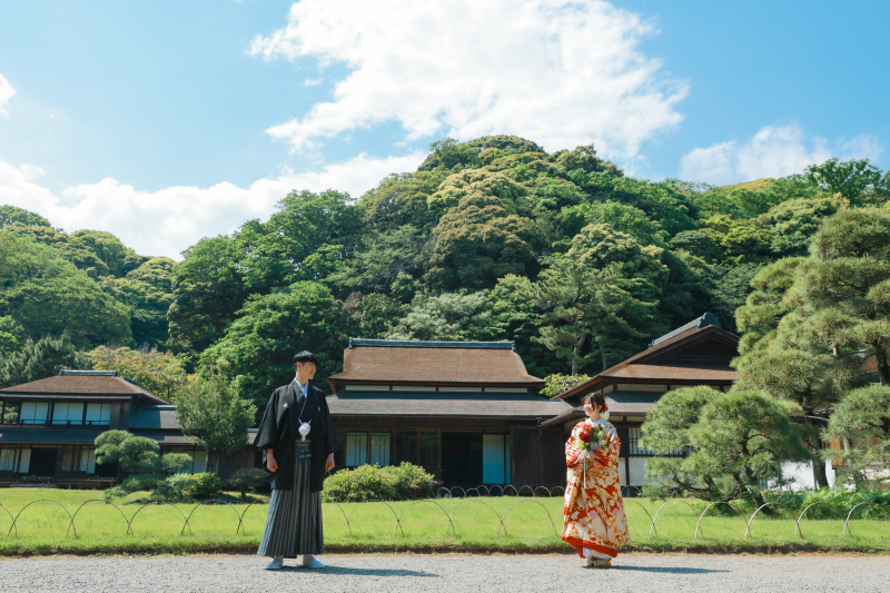 歴史ある茅葺き屋根の佇まいを背に。