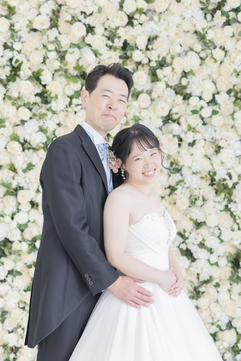 フラワーウォールを背に寄り添うふたり