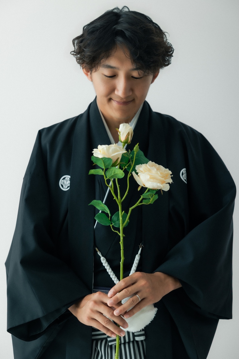 優しくお花を見つめる、新郎のソロカット