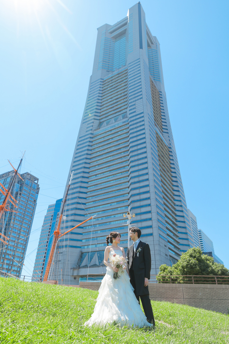 青空にそびえ立つランドマークタワーを背に