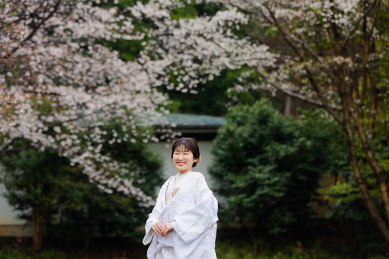 桜を背に、輝くような白無垢姿
