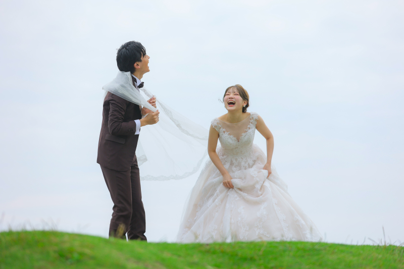 草原で大笑いするふたり