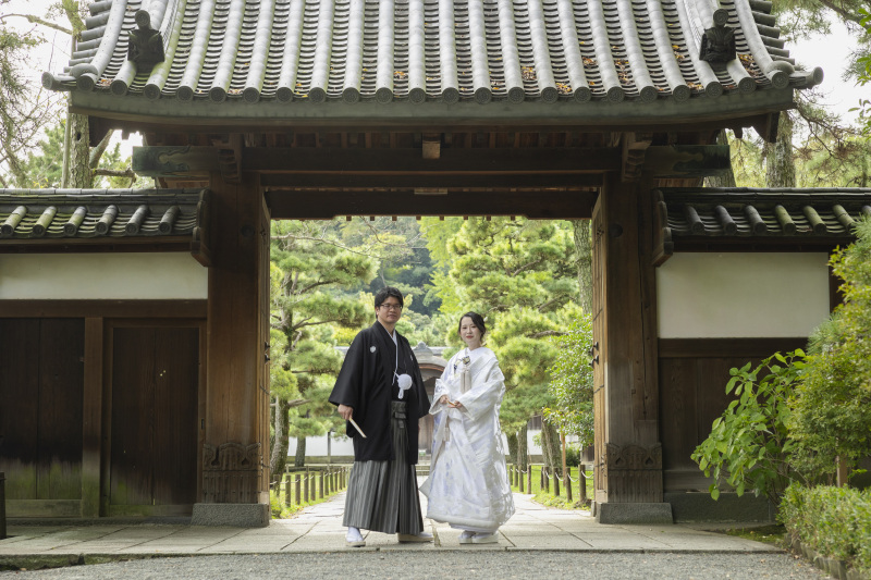 門の前でかっちり立ち姿も