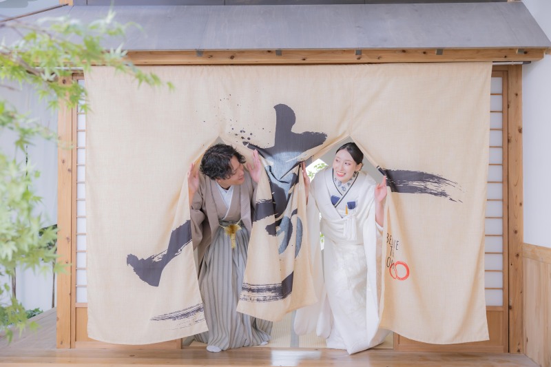 のれん越しに覗く二人の笑顔